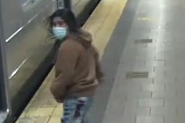 A screenshot from security camera footage shows a man with long ark hair running through a subway station. Police suspect he is responsible for a fatal stabbing at Chambers Street.